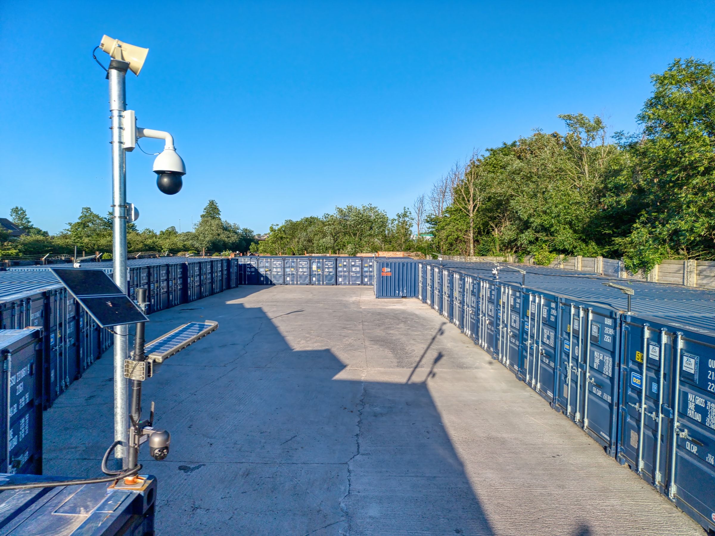 Elevated view across the storage yard with a dome CCTV camera overlooking rows of containers