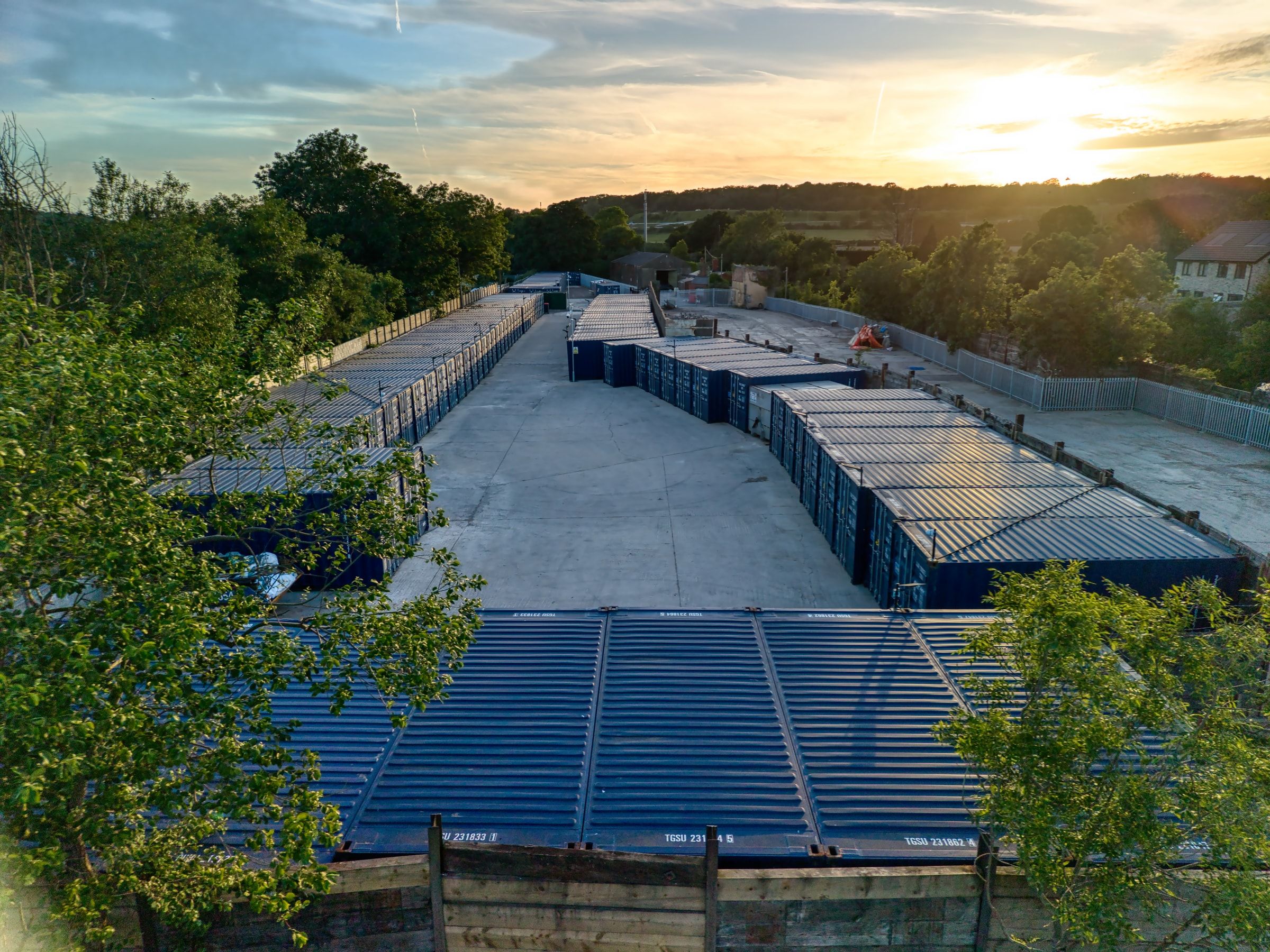 Aerial view of the whole Discount Storage facility at sunset, container rows ringed by trees in Henbury, Bristol