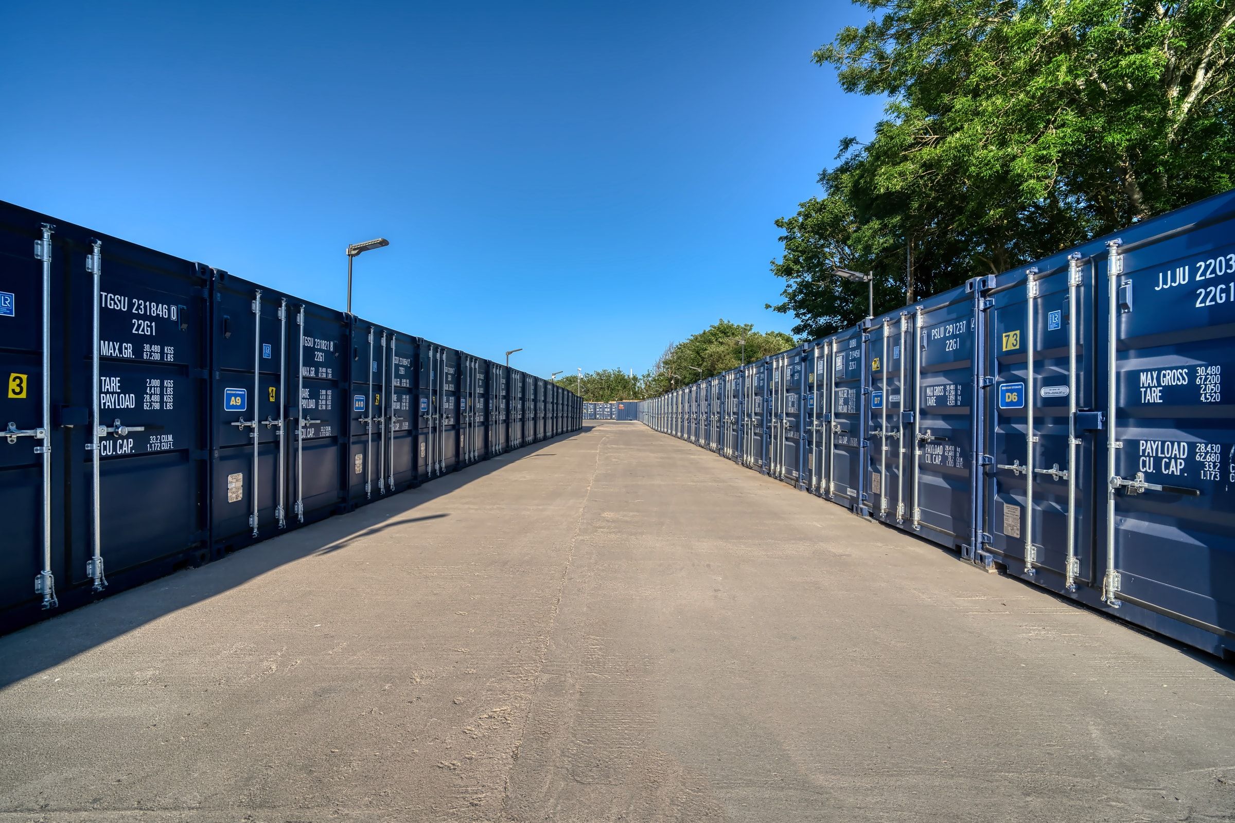 Two long rows of navy storage containers meeting at the central drive-up lane on a bright day